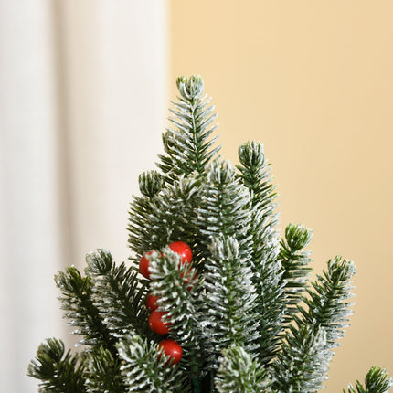 Snow-covered table Christmas tree with berries and pine cones