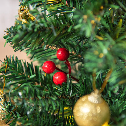 Small green Christmas tree with LED lights and berries